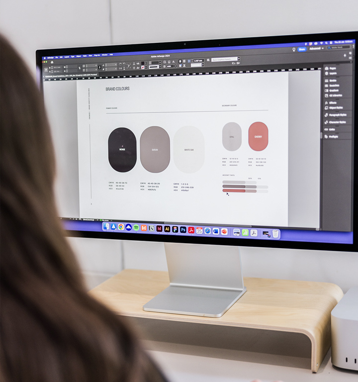 Focused designer at Four Stripes Design Agency evaluating a palette of brand colors on a monitor, reflecting the critical design decisions in brand identity creation within the agency's detail-oriented workflow.