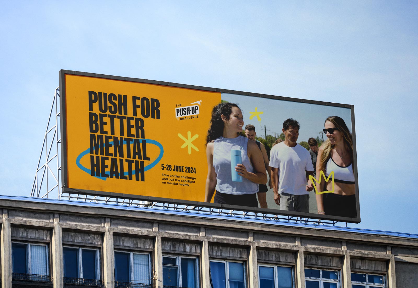 A billboard sands on top of a building sporting The Push-Up challenge 2024 campaign branding artwork