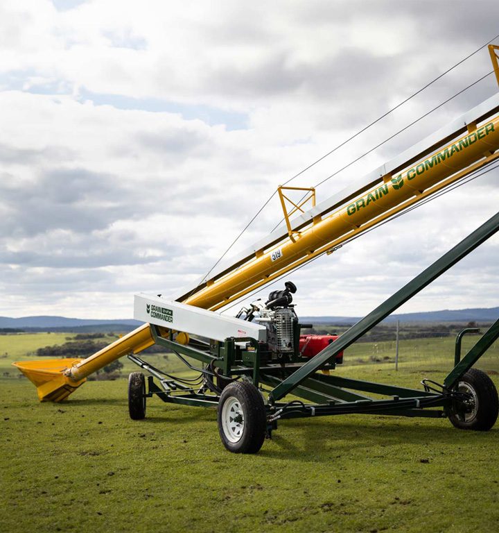 An auger in a field is branded with commander agriculture logo design
